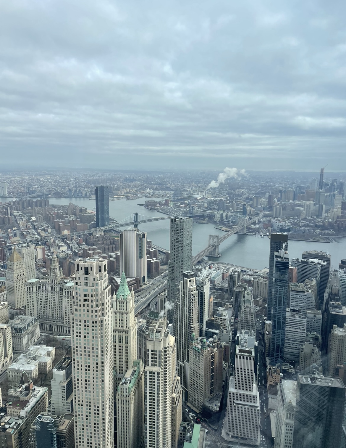  View of New York City from the 102 floor of the Prudential Tower. The sky is cloudy and the brooklyn bridge is in the frame.